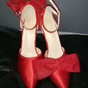 Asymmetrical bow red pumps